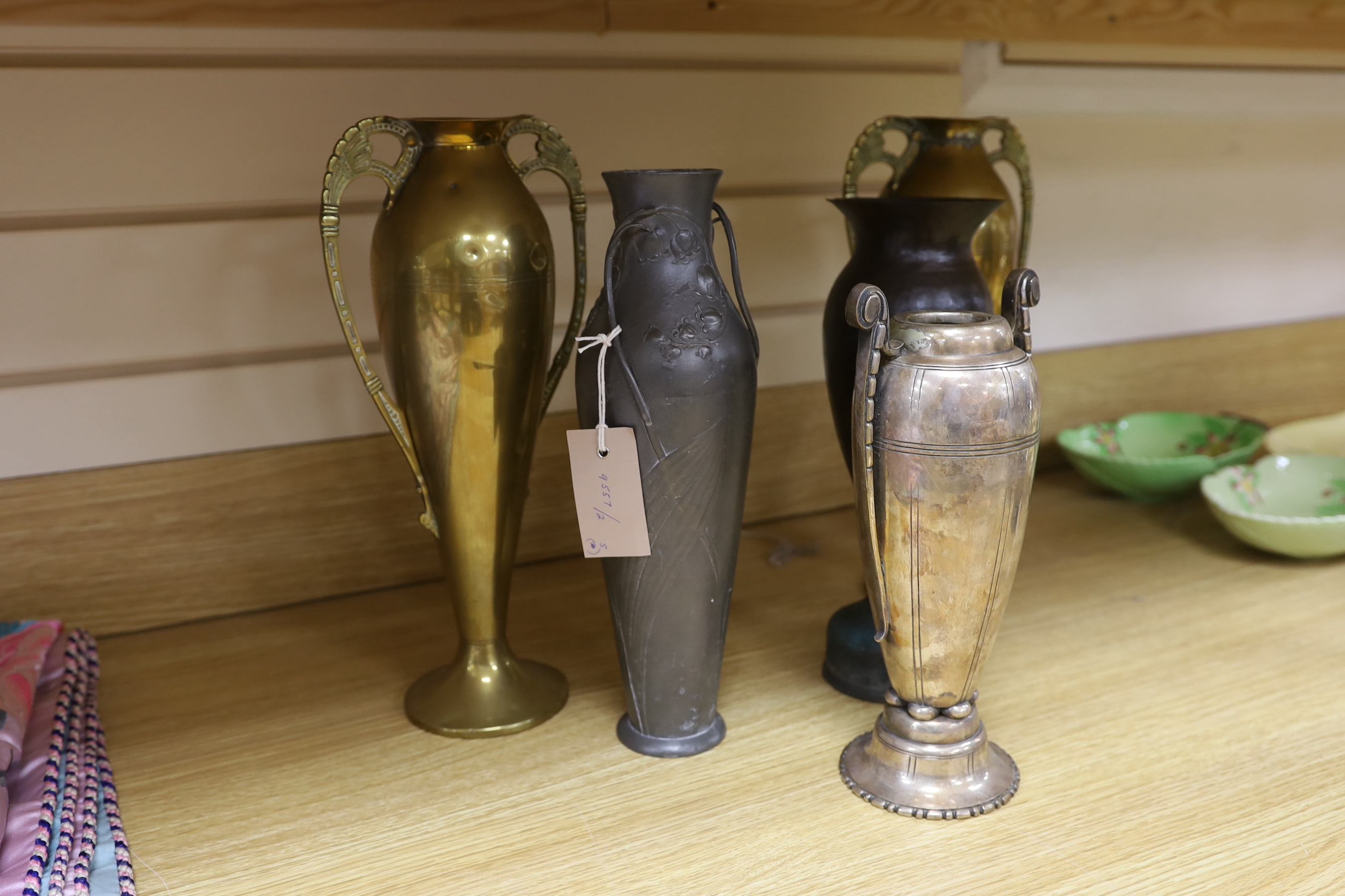 A Kayserzinn Art Nouveau pewter vase, a pair of brass vases, a plated vase and trench art vase